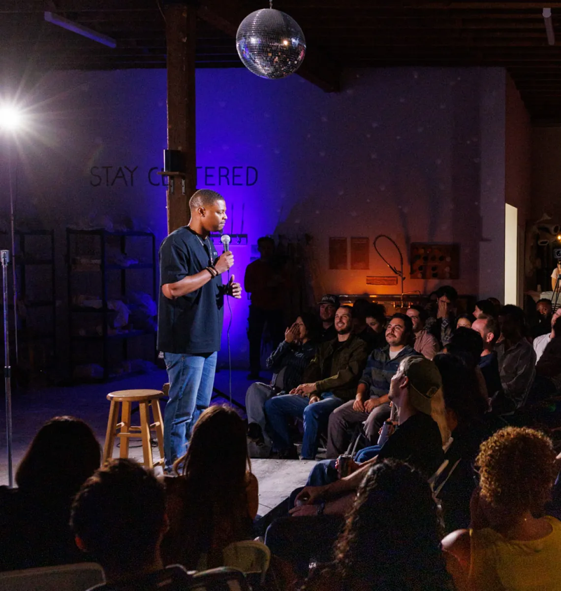 A comedian on stage at a packed Hambone Comedy night