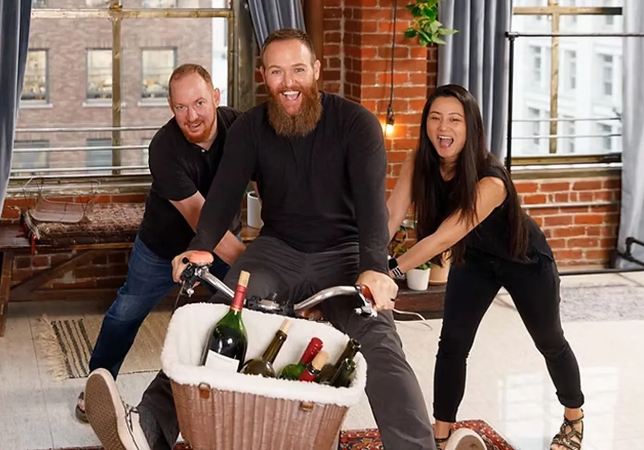 Three performers on a wine delivery bike during a shoot